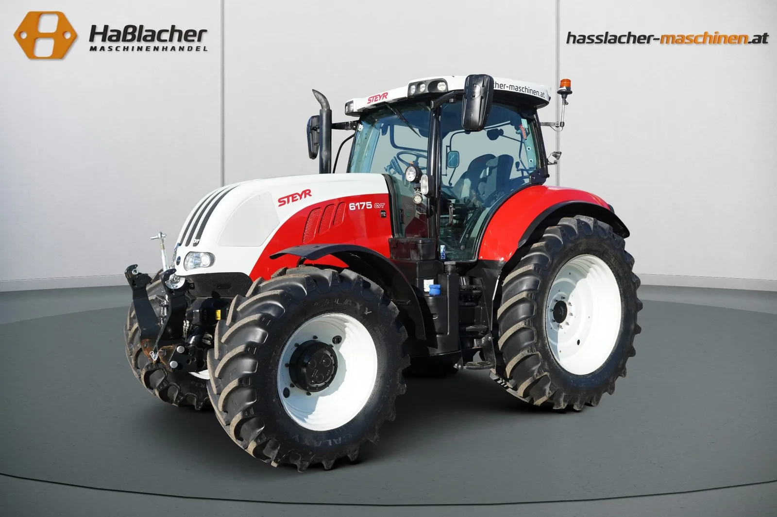 Weiß-roter Steyr Traktor vor der Haßlacher-Fotowand