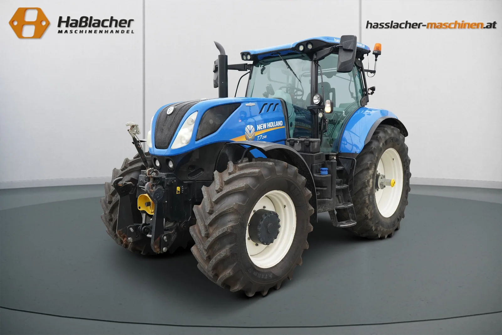 Blauer New Holland Traktor mit Fronthydraulik vor der Haßlacher-Fotowand