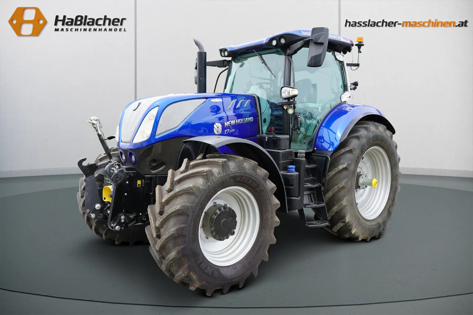 Dunkelblauer New Holland Traktor mit breiten Reifen vor der Haßlacher-Fotowand